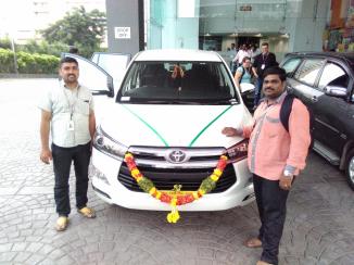 The proud drivers with their new car. It just came from it's blessing. The decorations are part of the blessing.