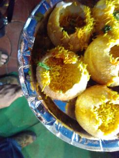 A Pani Poori with a chutney and sweet-and-sour sauce. Eat it fast or it falls apart.